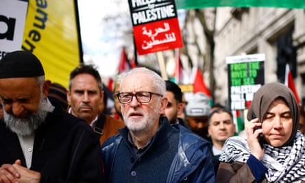 Jeremy Corbyn with pro-Palestinian activists and supporters at a protest in central London, 30 March 2024: he wears a dark blue anorak and glasses, and is pictured in a crowd of people with banners and placards