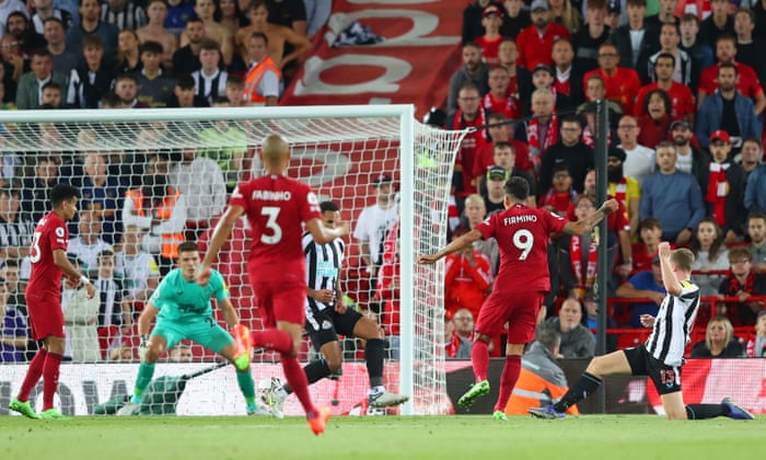 Roberto Firmino slots home Liverpool's equaliser despite being under pressure from Matt Targett of Newcastle.