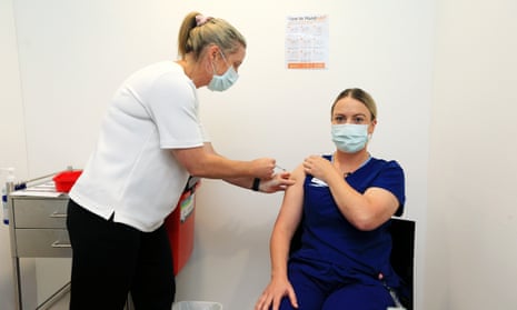 Covid screening nurse Grace Gibney receives one of the first Pfizer coronavirus vaccines from nurse practitioner Sonja Elia at Austin Health in Melbourne.