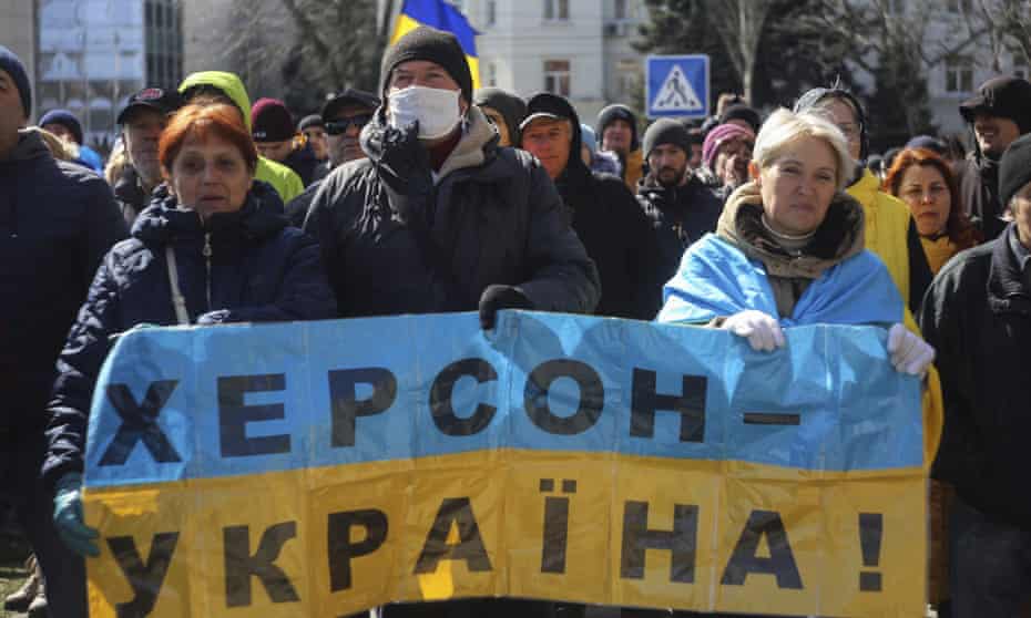 Kherson residents holding Ukrainian flag reading Kherson is Ukraine.