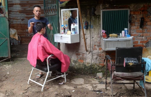 A barber serves a customer at his streetside shop. In a city where increasing numbers of Western salons cater to dapper urbanites with cash to spend, the city’s old-school sidewalk coiffeurs still do a brisk trade thanks to loyal customers and $1.30 haircuts