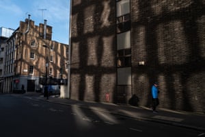 A lone figure in the light reflected from surrounding buildings, December 2020