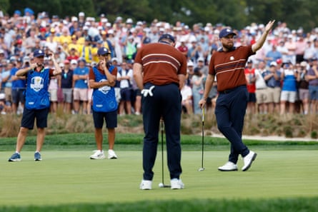 Shane Lowry reacts to the crowd as Rory McIlroy looks to putt on the 6th.