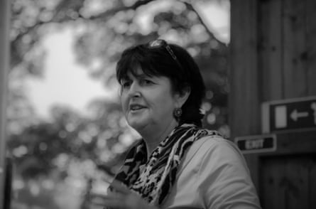 A black and white shot of a middle aged woman with short dark hair.