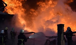 Firefighters work to put out a fire after missiles struck a fuel storage facility on the western Ukrainian city of Lutsk, on Tuesday.