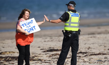 Godley adapts her Donald Trump protest placard and high-fives a police officer, 14 July 2018.