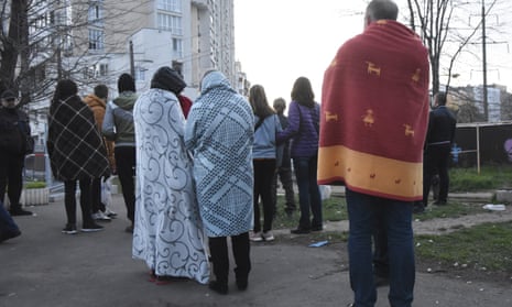 Residents stand covered by blankets next to their houses damaged by Russian shelling in Odesa, Ukraine, Saturday, April 23, 2022. Ukrainian officials reported that Russia fired at least six cruise missiles at the Black Sea port city of Odesa, killing five people.