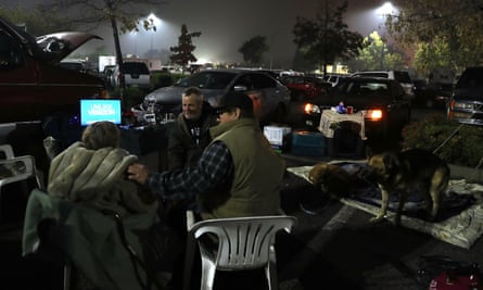 Camp fire evacuees watch television as they camp in a Walmart parking lot in Chico.