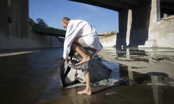 Fernando Lopez dresses after bathing in the Los Angeles river on 20 November 2015 in Los Angeles, California.