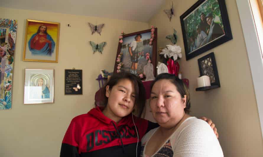 Stephanie Hookimaw, right, and her niece Karrisa Koostachin pose next to memorial photos of her daughter, Sheridan Hookimaw, who committed suicide in October.