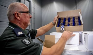 An officer of the customs authorities in the port of Rotterdam shows one of the seized boxes of vodka.