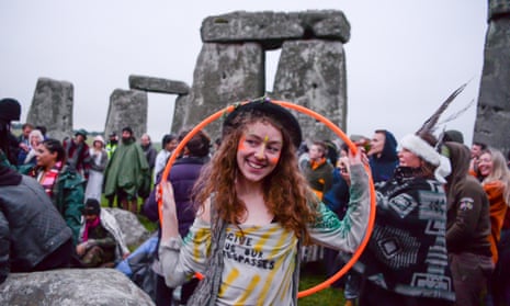 ‘Forgive us our trespassers,’ says a woman’s T-shirt as she holds a hula hoop at Stonehenge on Monday.