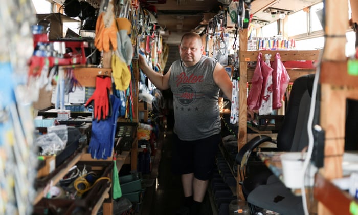 Andrey, 46, poses inside the bus that he turned into a shop to sell truck equipment for drivers near a petrol station in Khorol, Ukraine. REUTERS/Nacho Doce.