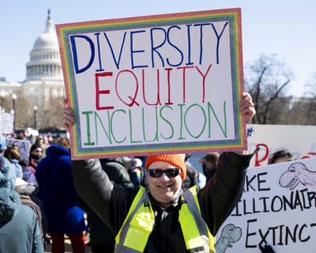 A person with a sign saying ‘‘Diversity equity inclusion’’.