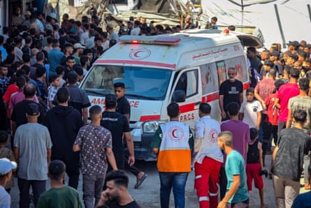 People crowd around an ambulance