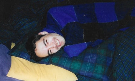 Miguel lies under a blanket on the sofa, smiling