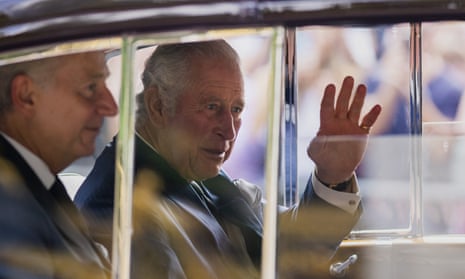 King Charles III greets supporters as he arrives at Buckingham Palace