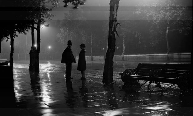 A man stops to talk to a policeman in the rain on the Thames embankment, 1929.