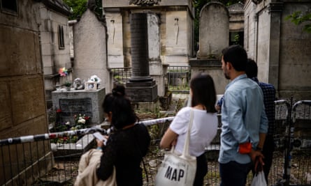 Visitors look at the grave of US singer and songwriter Jim Morrison.