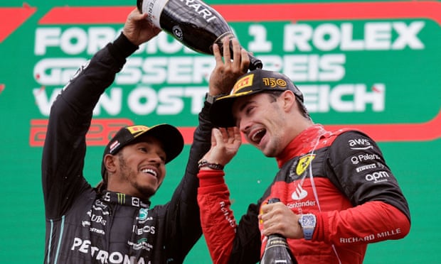 Lewis Hamilton menuangkan sampanye di atas kepala Charles Leclerc di podium di Red Bull Ring