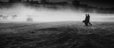 Two people walking side by side with mist in front of them