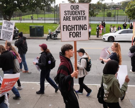 Teachers, students and supporters on the pavement outside holding placards