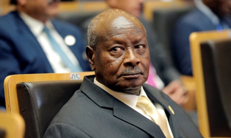 An elderly African man in a suit looks off camera