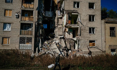 A local resident pulls a cart past a damaged building in the town of Bakhmut amid the Russian invasion of Ukraine.