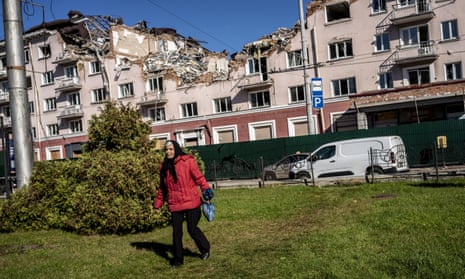 An elderly woman in front of a bomb-damaged building in Chernihiv Oblast.