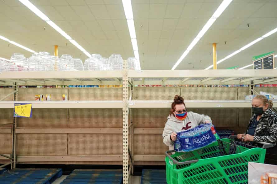 Shoppers at a Houston supermarket pass bare shelves. The winter weather has caused water and food shortages.