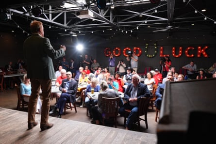 a man speaks to a room full of people
