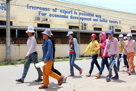 Women walk past a factory
