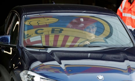 Barcelona’s coach Ernesto Valverde leaves Joan Gamper training camp, as the team’s logo is reflected on the window of his car.