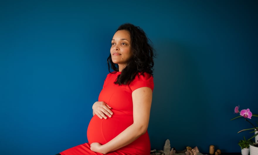 A portrait of Valenttina Griffin, wearing a red dress while heavily pregnant 