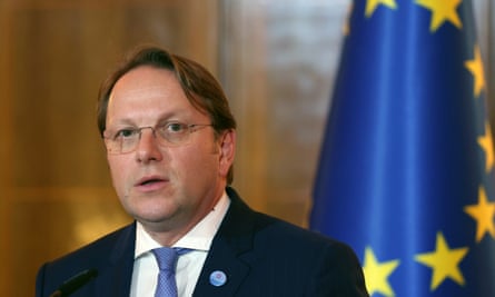 Olivér Várhelyi stands in front of an EU flag
