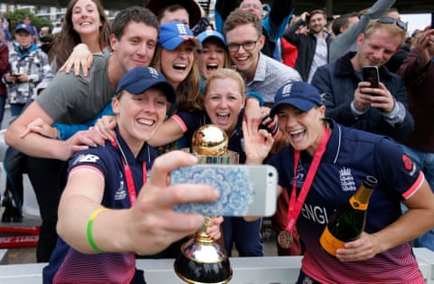 The England women’s cricket team captain Heather Knight, left, and team-mate Katherine Brunt celebrate with the trophy and fans after victory in the World Cup Final against India at Lords Cricket Ground.