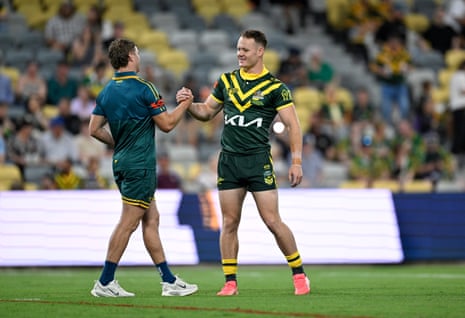 Ethan Strange and Blayke Brailey clasp hands and smile on the rugby field