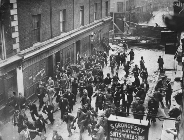 Demonstrators flee as police break down a barricade in Cable Street during the battle.