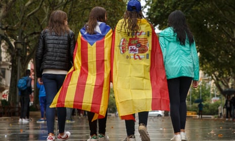 Girls stroll through the center of Figueras with the Spanish and a pro-independence Catalan flag