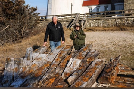 Tony Femminella of the Fire Island Lighthouse Preservation Society, and Betsy DeMaria from the Fire Island National Seashore, stand beside a section of the hull of a ship believed to be the SS Savannah.