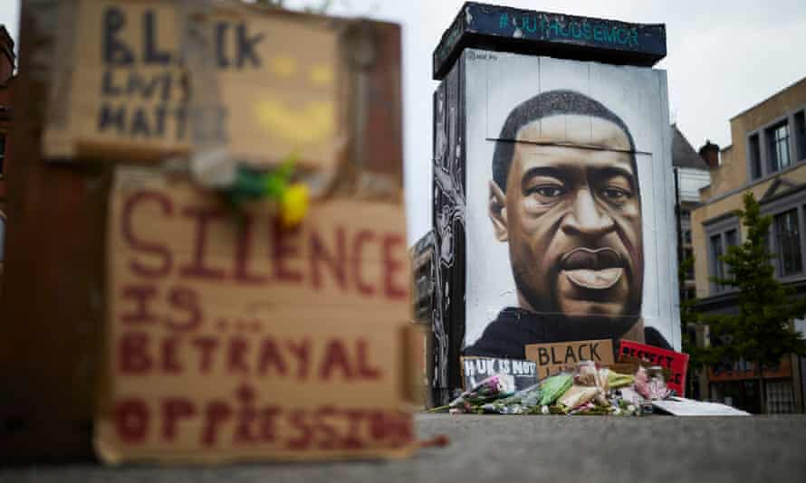 Flowers and tributes surround street artist Akse’s mural of George Floyd in Stevenson Square, Manchester, UK.