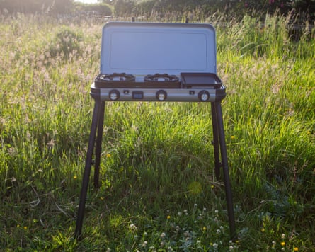 A Campingaz Camping Kitchen 2 Multi-Cook Plus Gas Stove stands in a field
