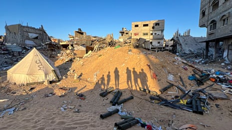 Silhouettes of children are seen on Thursday near the US-origin weapons and ammunition that were used by the Israeli army in the ground operation, after their withdrawal from Khan Younis city.