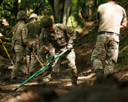 Soldiers working in a wooded area.