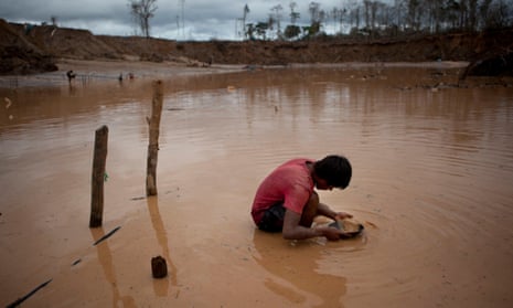 A boy searches for gold at an illegal mine in La Pampa, in the Madre de Dios region of Peru, 2014.
