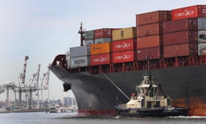 A cargo ship full of shipping containers making its way up the Yarra River in Melbourne.