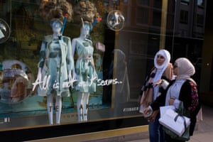 Two Muslim women walk past a shop display in central London.