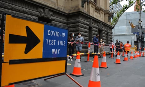 People line up outside the Melbourne town hall next to a Covid-19 testing sign