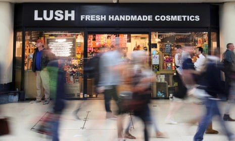 People walk pass a Lush cosmetics store in London