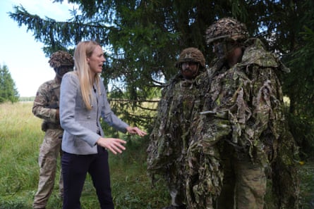 Louise Sandher-Jones appears to react with alarm at the sight of two soldiers in full camouflage kit